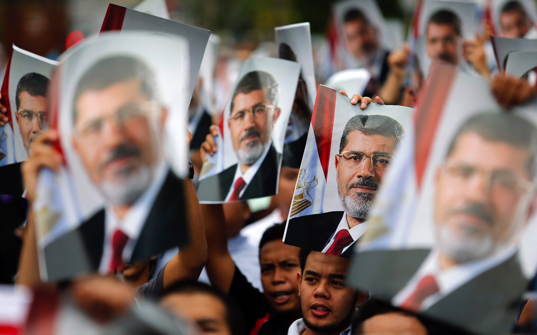 Supporters of Egypt's ousted Islamist President Mursi hold his pictures during a demonstration outside the Egyptian embassy in Kuala Lumpur