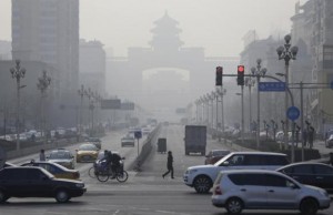Pedestrians cross the road on a hazy day in Beijing