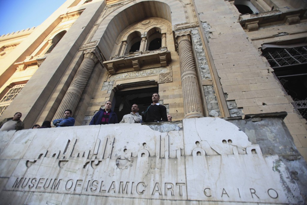 Police officers and people gather in front of damaged Museum of Islamic Art building, after a bomb blast in Cairo