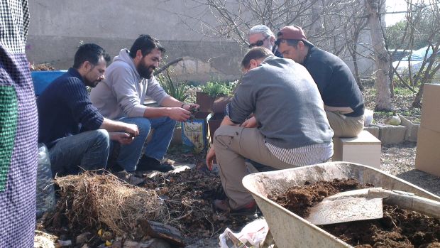 ÇEYO katılımcısı beyler kompost kutularının yataklıklarını hazırlarken koyu bir sohbete dalmış durumda