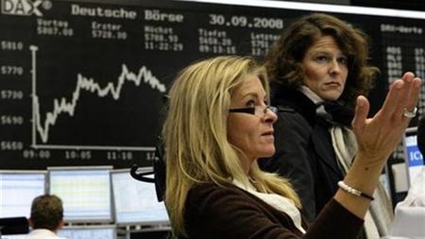 Traders react in front of the DAX board at the Frankfurt stock exchange