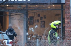 Police presence is seen next to damaged glass at the site of a shooting in Copenhagen