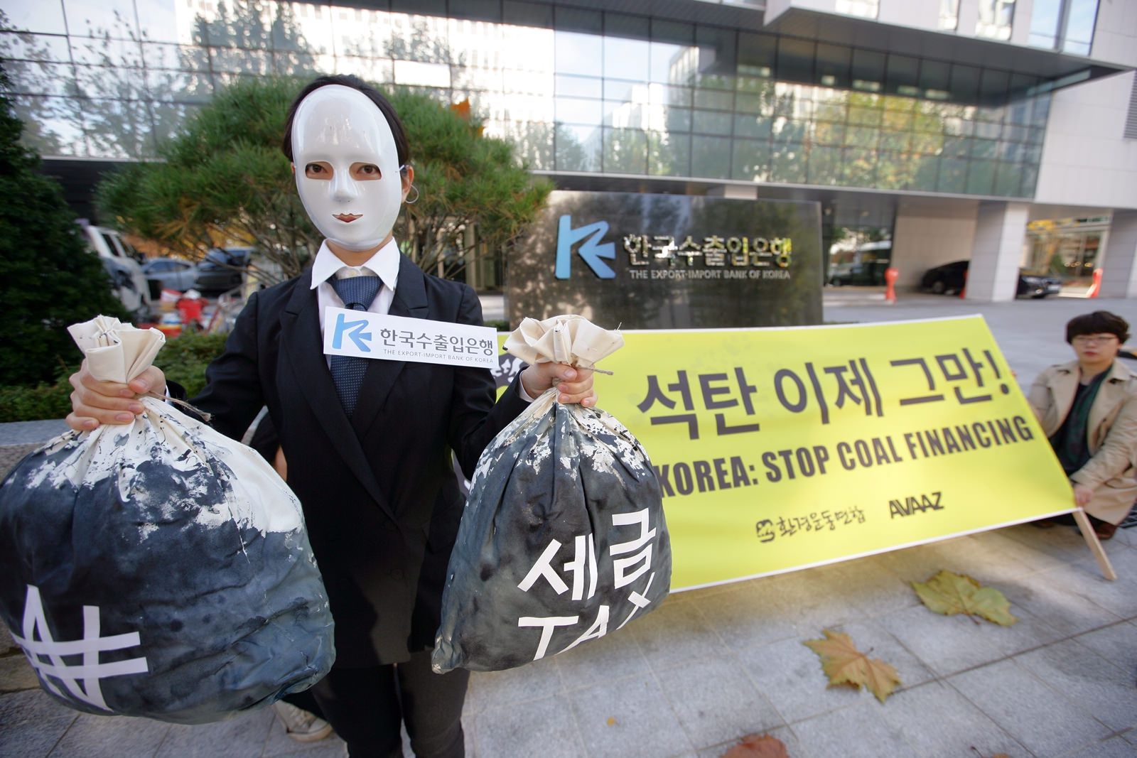Korea Import-Export Bankası önünde, aktivistler kömür projelerinden yatırımlarını çekme çağrısı yaparken