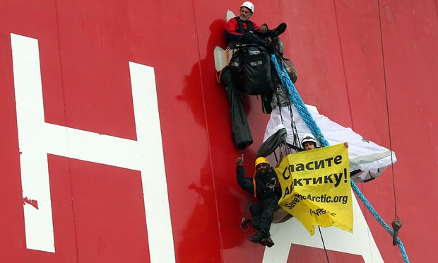 Naidoo 2012’de Pechora Denizi’nde, Prirazlomnaya petrol platformuna tırmanırken ve üstünde Rusça “Kuzey Buz Denizi’ni öldürmeyin” yazan bir pankart taşırken eliyle tamam işareti yapıyor. Fotoğraf: Denis Sinyakov/AP
