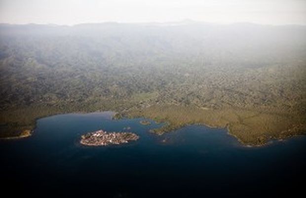 Kuna Yala’nın en yoğun nüfuslu adasının havadan görüntüsü ve arkada uzanan, Orta Amerika’nın en iyi korunmuş ormanlarından biri olan Kuna’nın kutsal ormanı. Panama’nın kuzeydoğu kıyısında uzanan Kuna adaları fırtınalar ve deniz seviyesi yükselmesi sebebiyle sıklıkla sel altında kalmakta ve bu da Kuna’lıların tüm toplulukları anakaraya taşımayı düşünmesine sebep olmakta. Fotoğraf: Roberto (Bear) Guerra