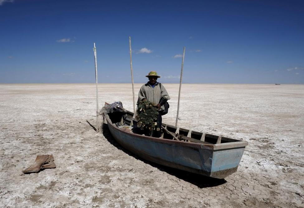 Urus etnik grubundan olan Balıkçı Rene Valero, botunun üstünde kurumuş göl yatağının üzerinde görünüyor. Yerli aileler, geçimlerinin büyük bir kısmını kaybetmiş olarak, göç etmeye zorlanıyor.