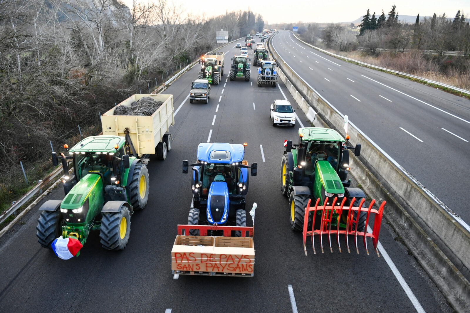 Farmers drive their tractors on a motorway near Orange, in southern France, in protest against taxation and falling incomes, on January 24, 2024.