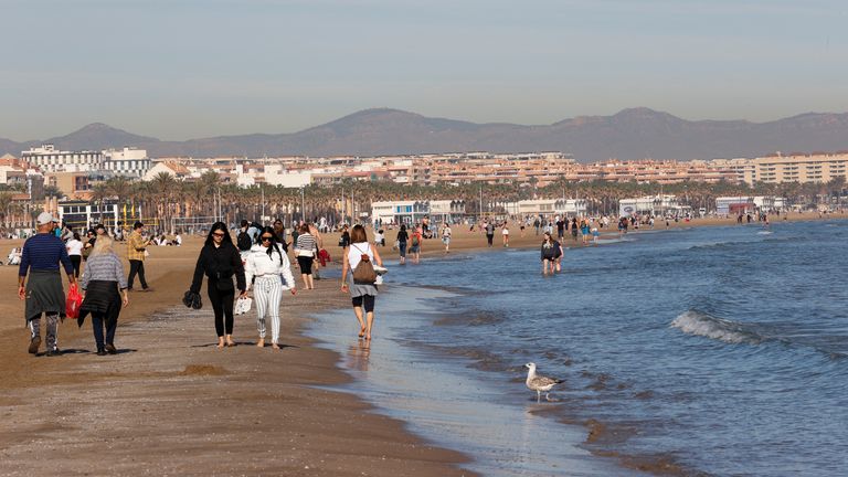 People walk along the seashore at the Malvarrosa beach in Valencia, Spain January 25, 2024 REUTERS/Eva Manez